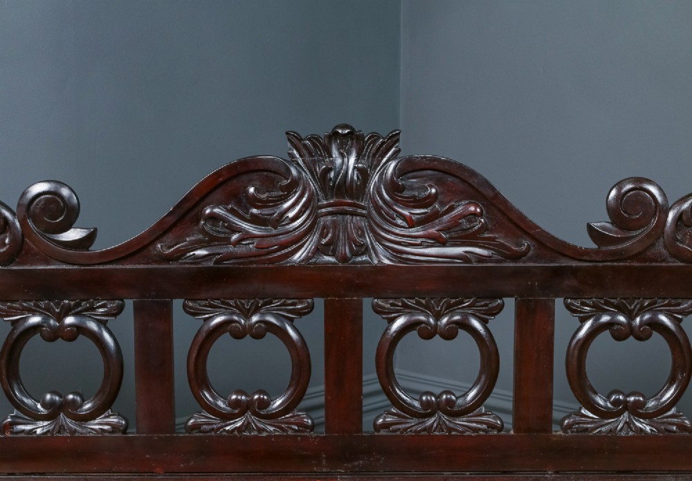 An antique dark timber king-size four-poster bed featuring spiral turned posts, a carved footboard with circular cut-out details, and an upper canopy frame. View IV