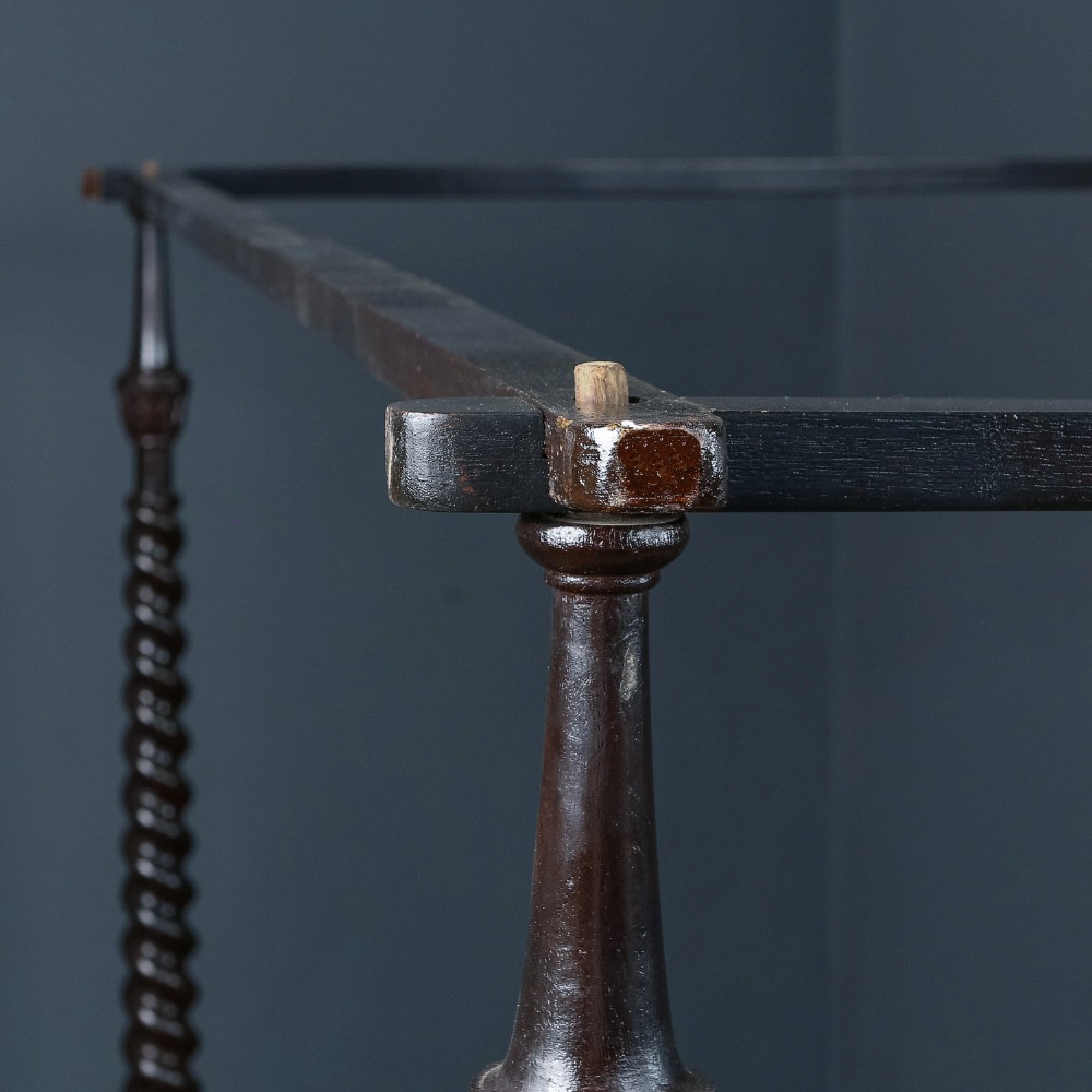 An antique dark timber king-size four-poster bed featuring spiral turned posts, a carved footboard with circular cut-out details, and an upper canopy frame. View VI