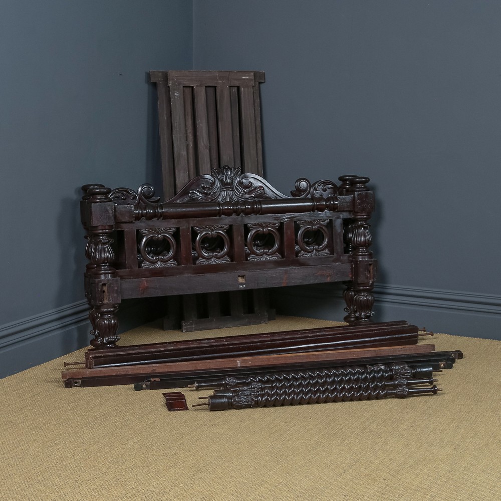 An antique dark timber king-size four-poster bed featuring spiral turned posts, a carved footboard with circular cut-out details, and an upper canopy frame. View XV