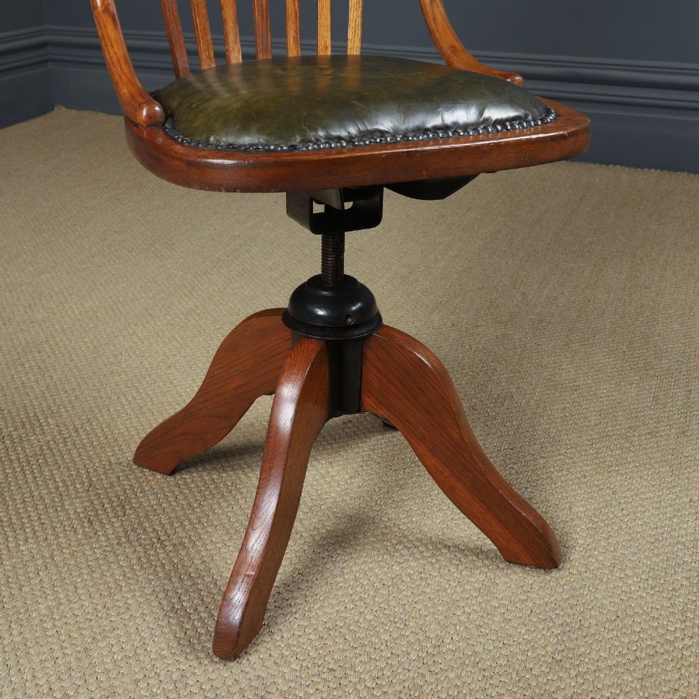 A George V period golden oak revolving desk chair featuring a curved spindle backrest, quadruped base, and a padded green leather seat secured with brass studs. View III