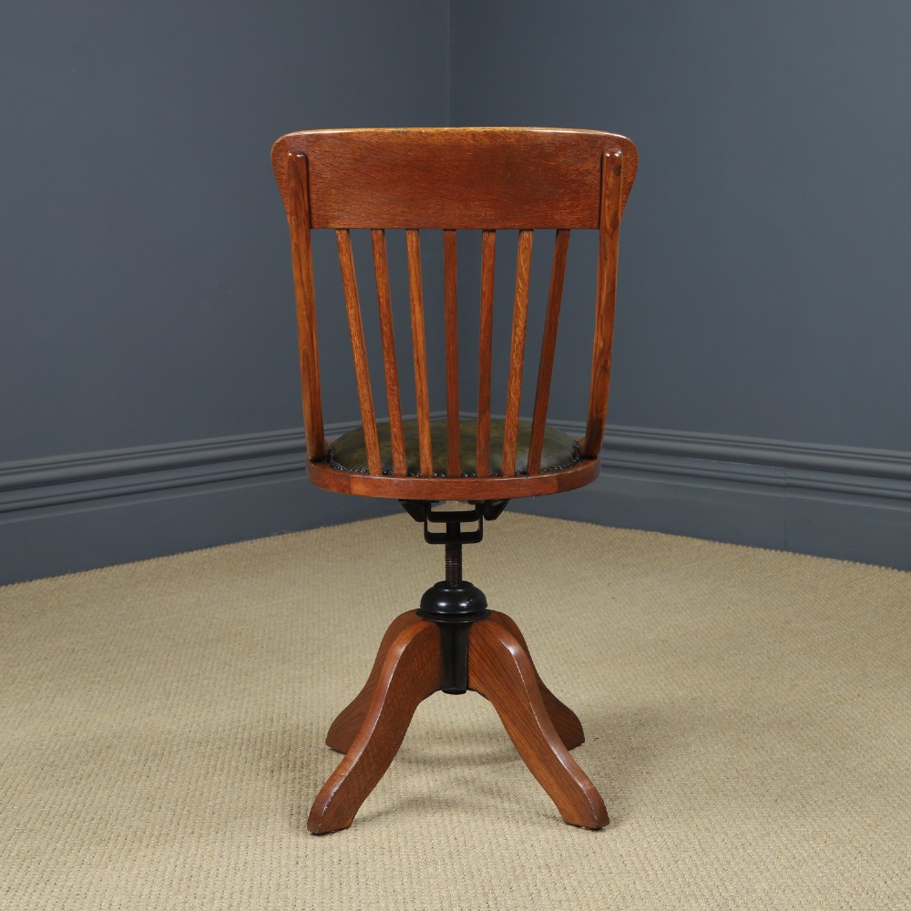 A George V period golden oak revolving desk chair featuring a curved spindle backrest, quadruped base, and a padded green leather seat secured with brass studs. View IX