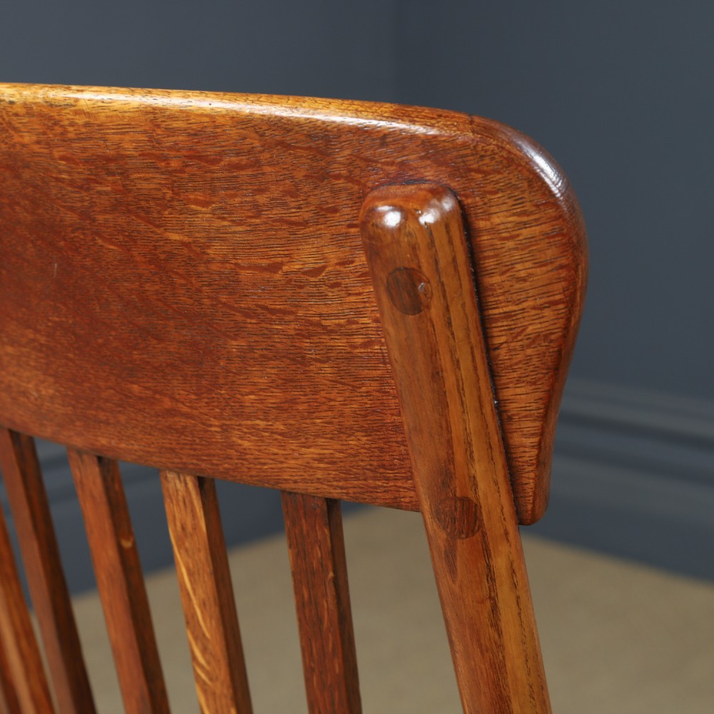 A George V period golden oak revolving desk chair featuring a curved spindle backrest, quadruped base, and a padded green leather seat secured with brass studs. View XI