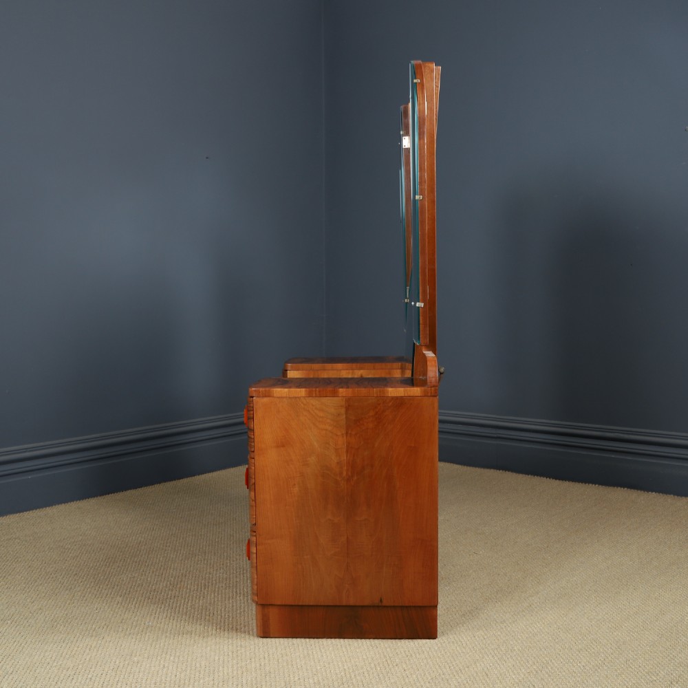 An Art Deco figured walnut dressing table featuring twin pedestal drawers, a central curved drawer, red handles, and a three-panel upright mirror. View XIII