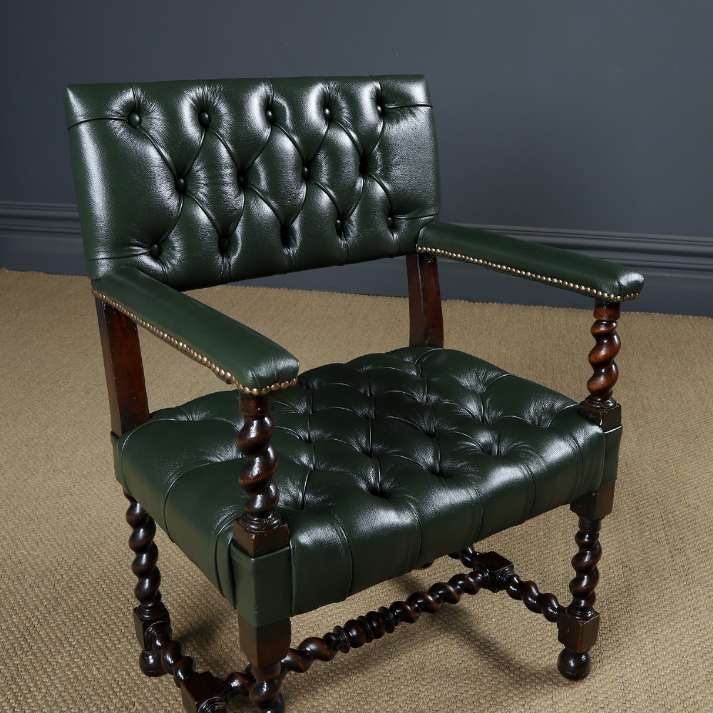 An antique 17th-century style dark oak armchair featuring deep-buttoned green leather upholstery, brass stud trim, and barley-twist turned legs and stretchers. View II