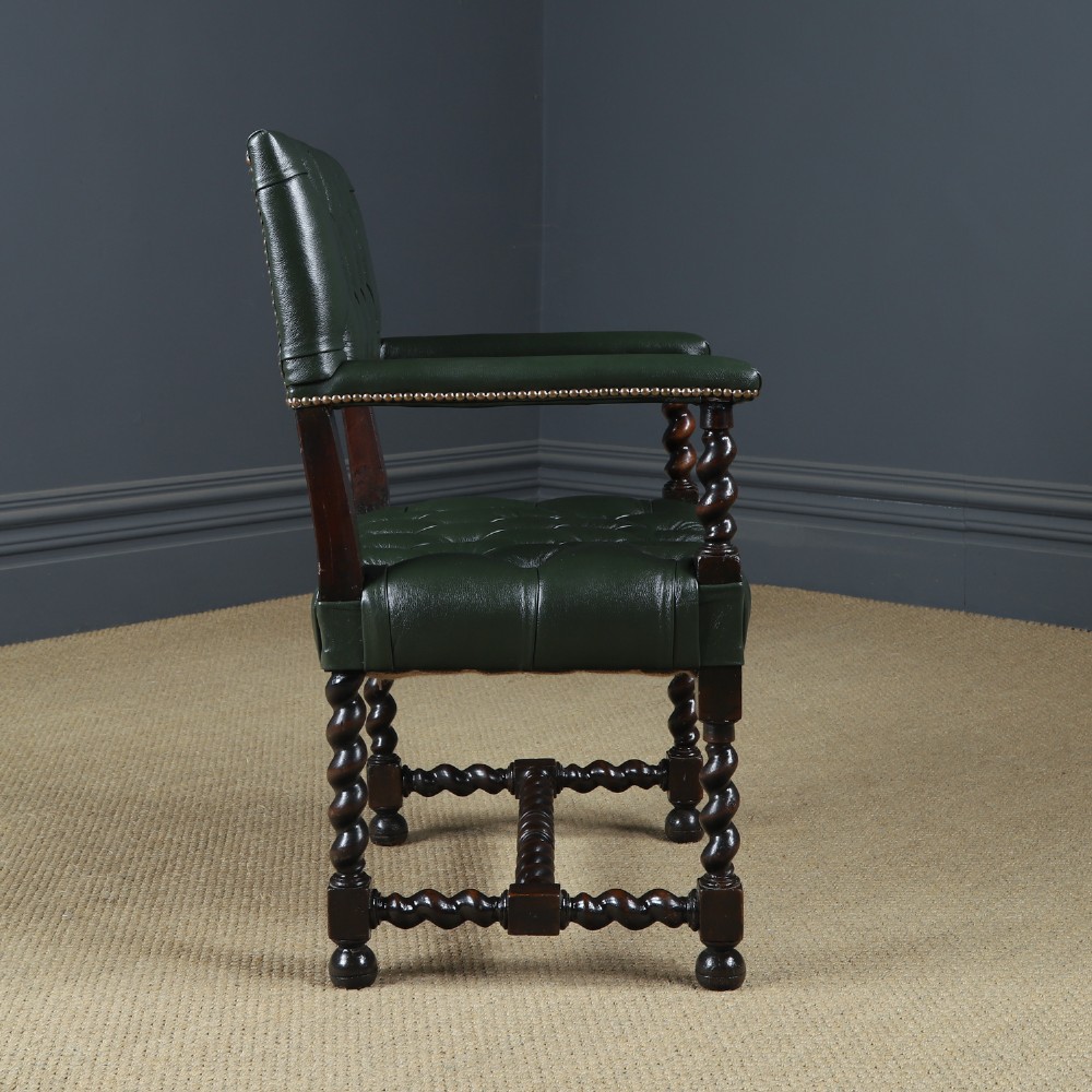 An antique 17th-century style dark oak armchair featuring deep-buttoned green leather upholstery, brass stud trim, and barley-twist turned legs and stretchers. View X
