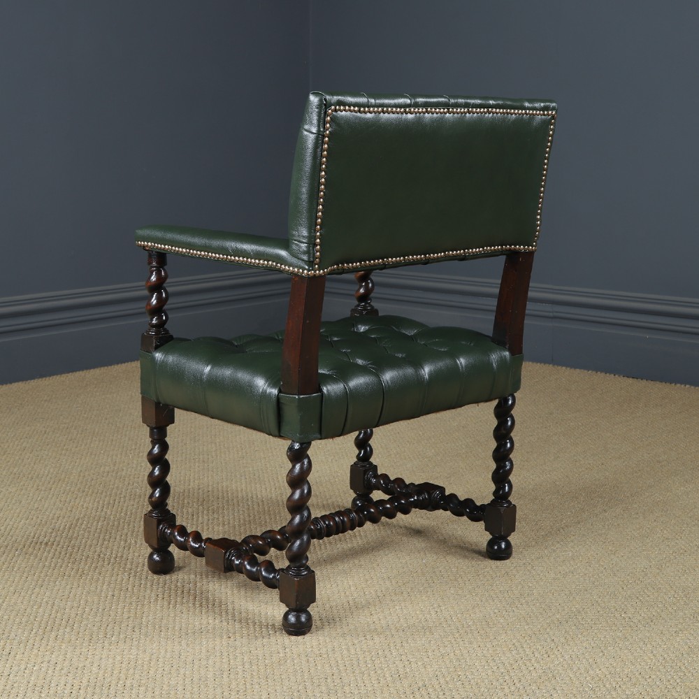 An antique 17th-century style dark oak armchair featuring deep-buttoned green leather upholstery, brass stud trim, and barley-twist turned legs and stretchers. View XII
