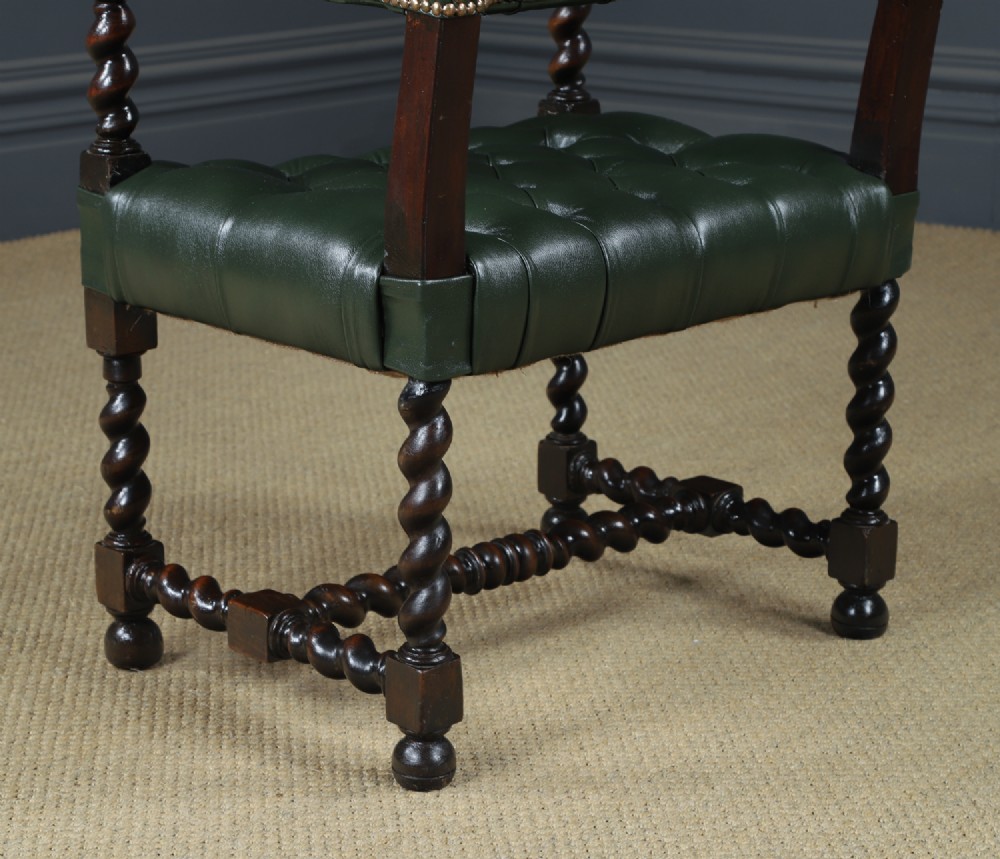An antique 17th-century style dark oak armchair featuring deep-buttoned green leather upholstery, brass stud trim, and barley-twist turned legs and stretchers. View XIII