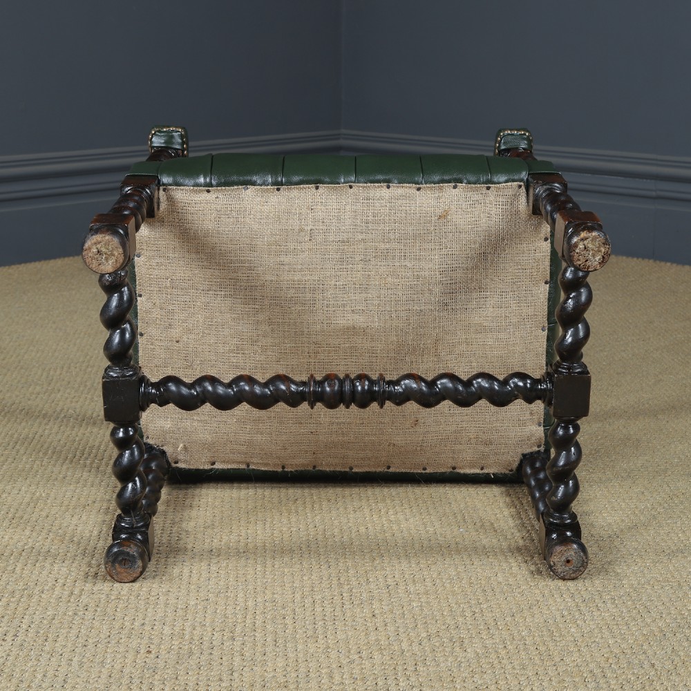 An antique 17th-century style dark oak armchair featuring deep-buttoned green leather upholstery, brass stud trim, and barley-twist turned legs and stretchers. View XV