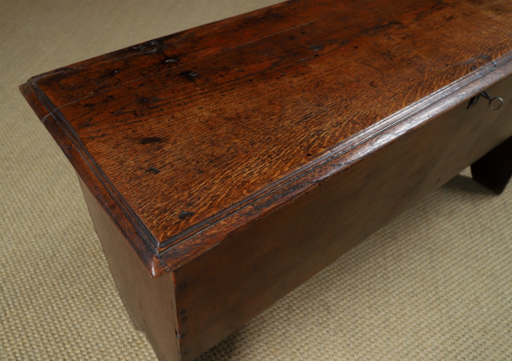A rectangular dark brown oak six-plank coffer featuring V-cut side legs and iron keyhole escutcheon detail. View VI