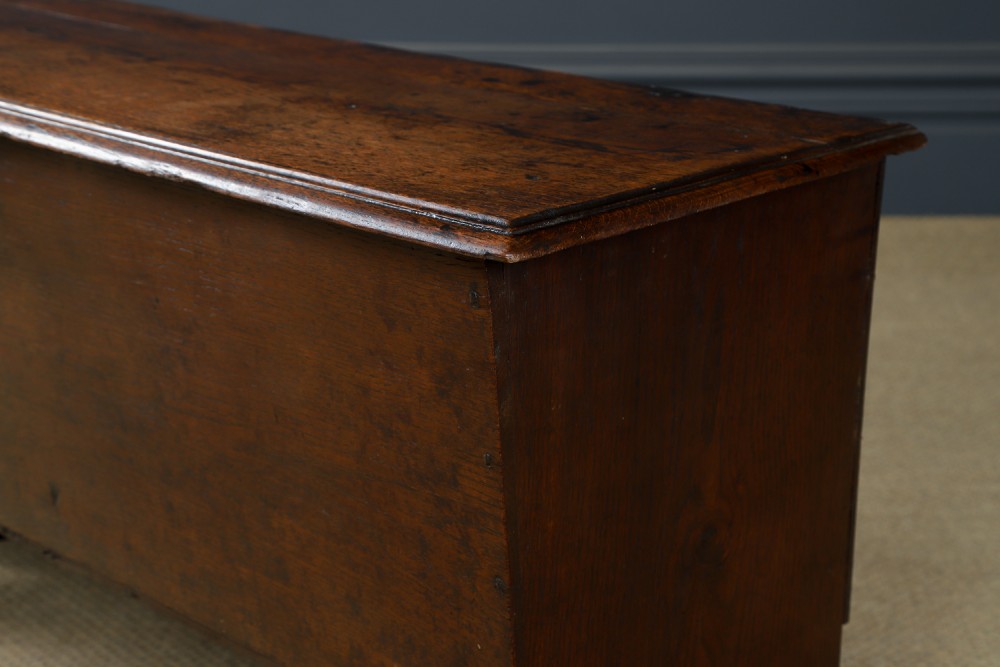 A rectangular dark brown oak six-plank coffer featuring V-cut side legs and iron keyhole escutcheon detail. View IX