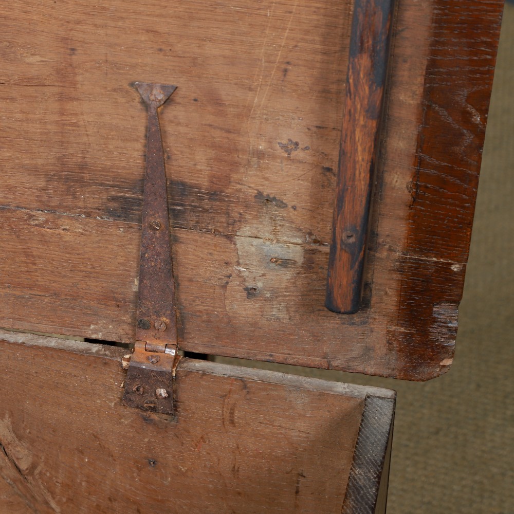A rectangular dark brown oak six-plank coffer featuring V-cut side legs and iron keyhole escutcheon detail. View X