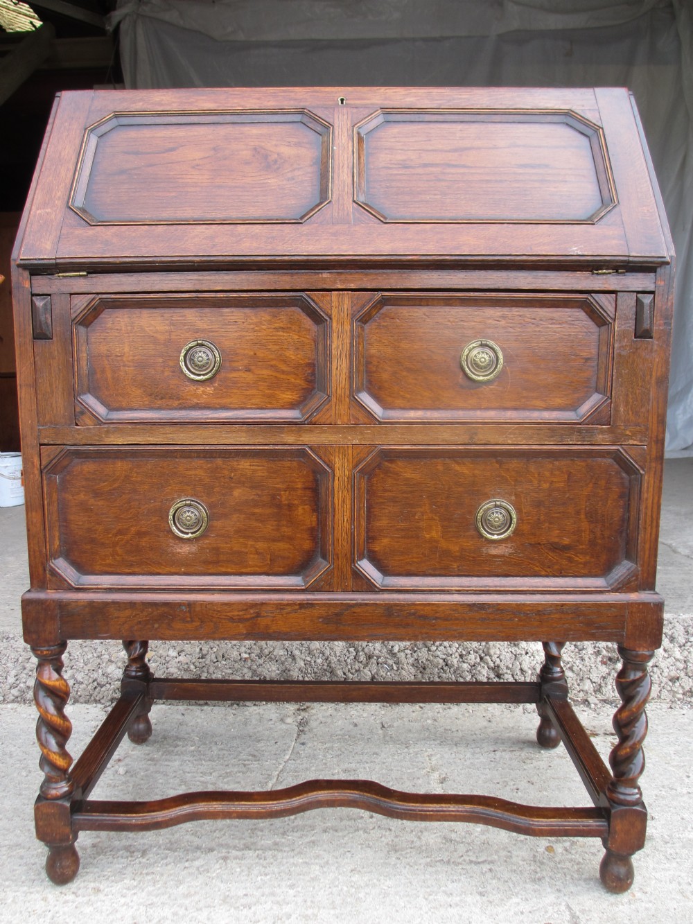 Solid oak Edwardian writing bureau desk with barley twist supports, two deep brass handled drawers with fall down front revealing stationary fitted interior
