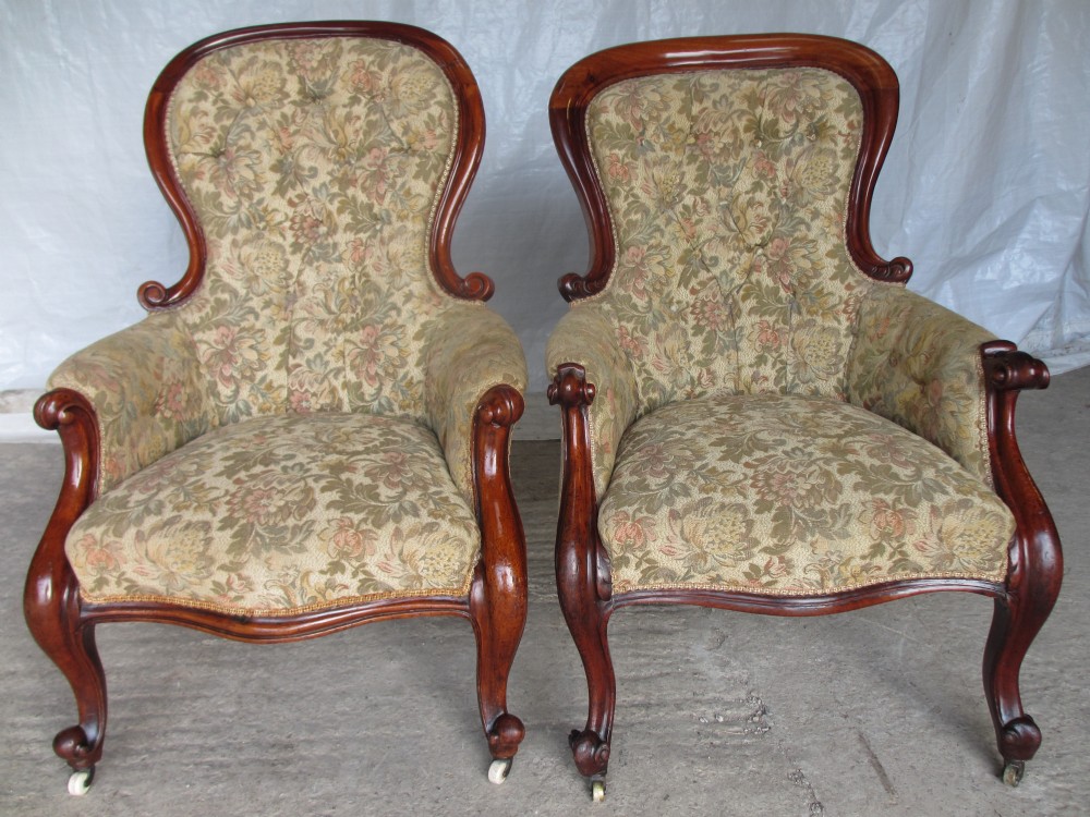 Matched pair of Victorian mahogany showood button upholstered armchairs with scroll spoon backs, scroll carved forelegs set on castors