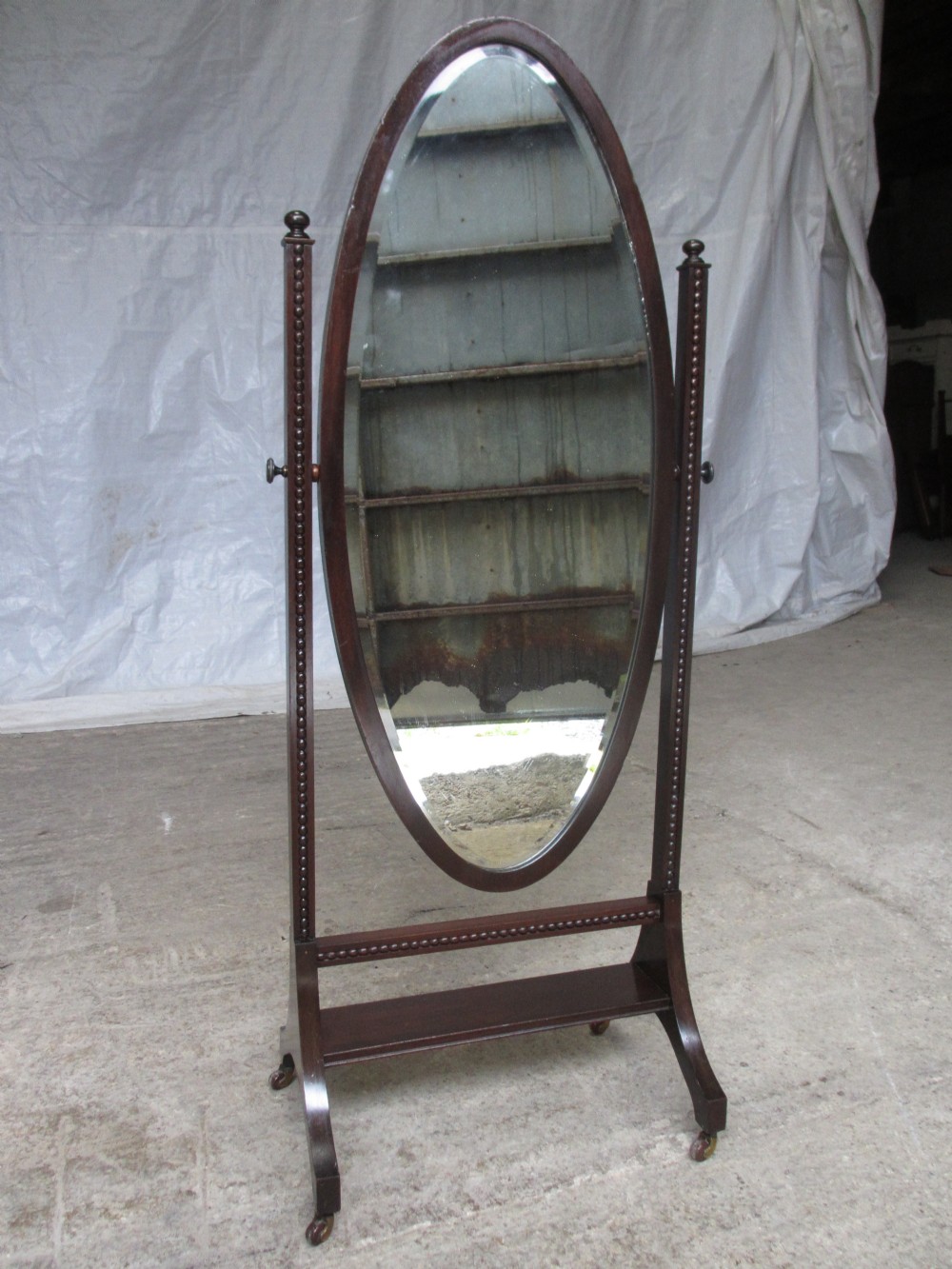Edwardian mahogany oval bevel edge cheval dressing mirror with beaded moulded supports set on castors
