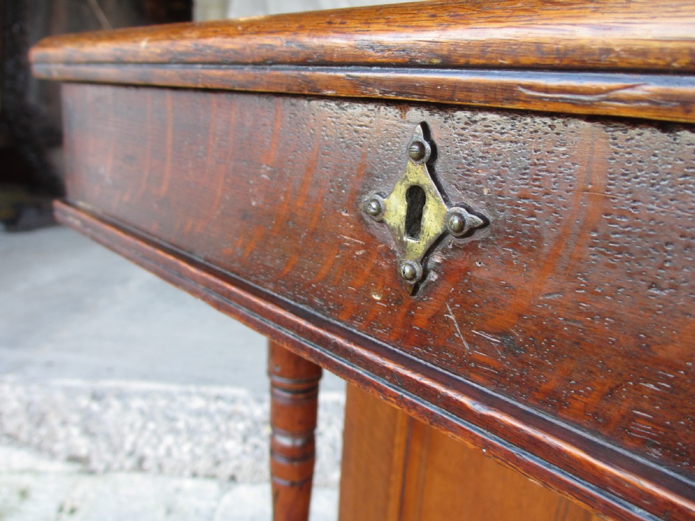 A Victorian oak davenport desk featuring a green leather writing surface, brass gallery rail, and turned front columns. View VI