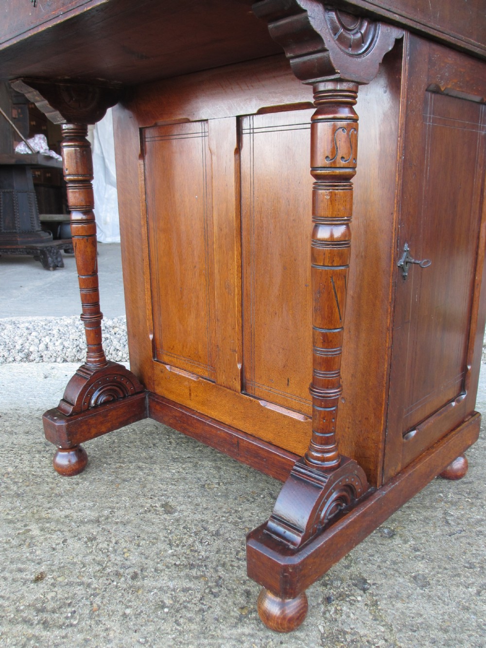 A Victorian oak davenport desk featuring a green leather writing surface, brass gallery rail, and turned front columns. View VII