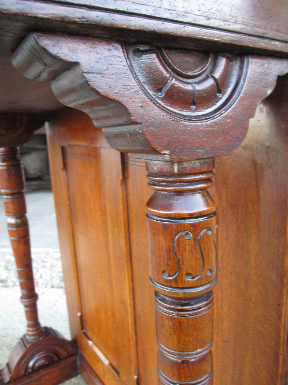 A Victorian oak davenport desk featuring a green leather writing surface, brass gallery rail, and turned front columns. View VIII