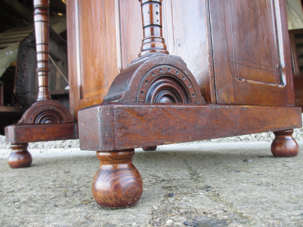 A Victorian oak davenport desk featuring a green leather writing surface, brass gallery rail, and turned front columns. View X