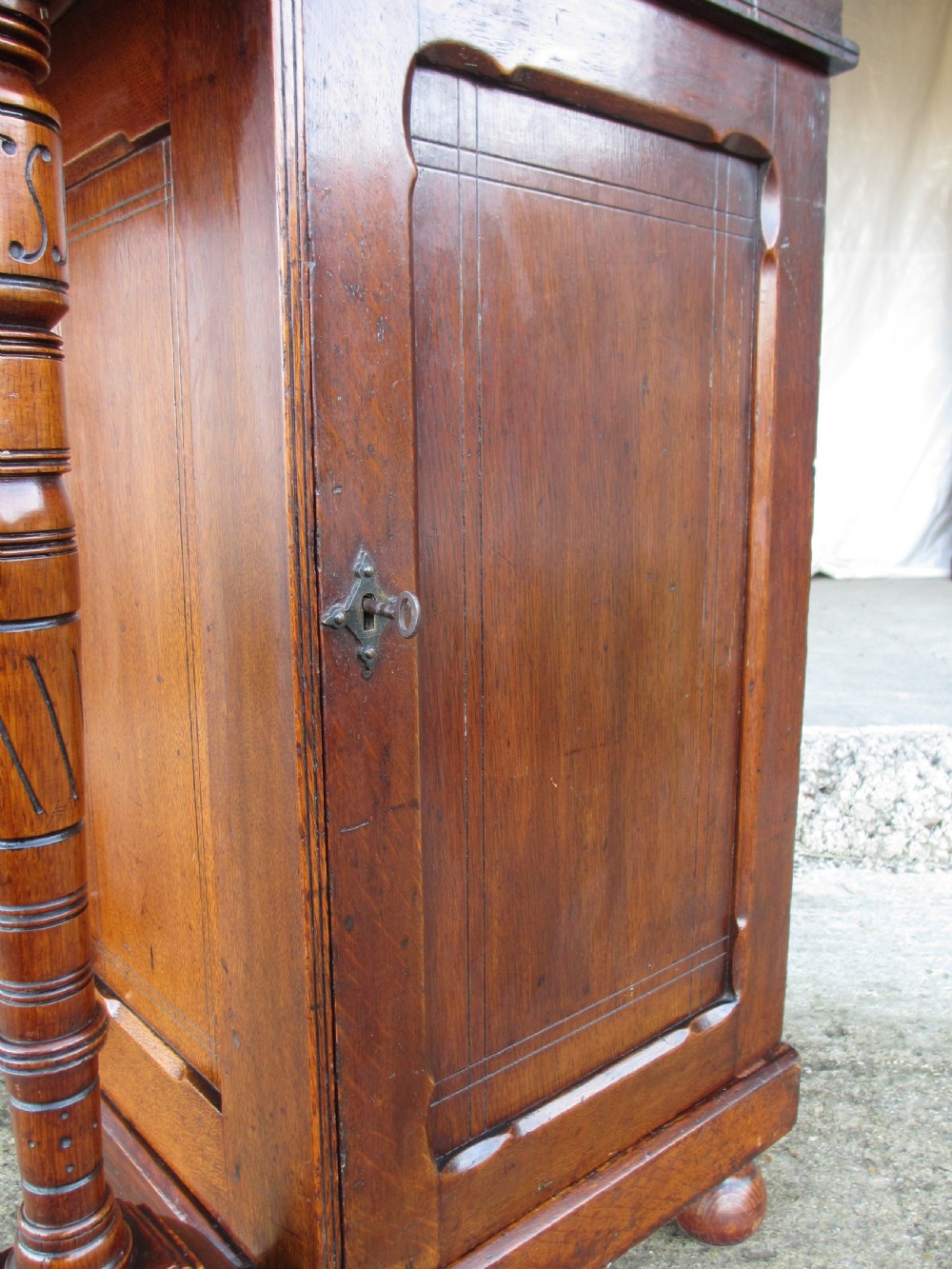 A Victorian oak davenport desk featuring a green leather writing surface, brass gallery rail, and turned front columns. View XI