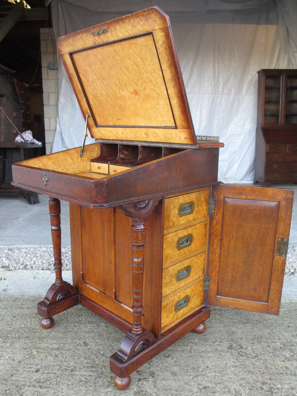 A Victorian oak davenport desk featuring a green leather writing surface, brass gallery rail, and turned front columns. View XIV