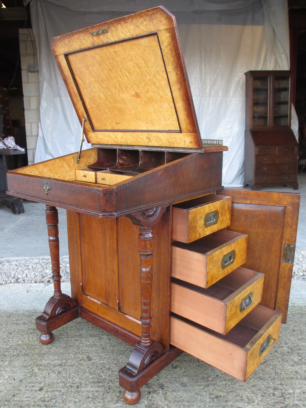 A Victorian oak davenport desk featuring a green leather writing surface, brass gallery rail, and turned front columns. View XV