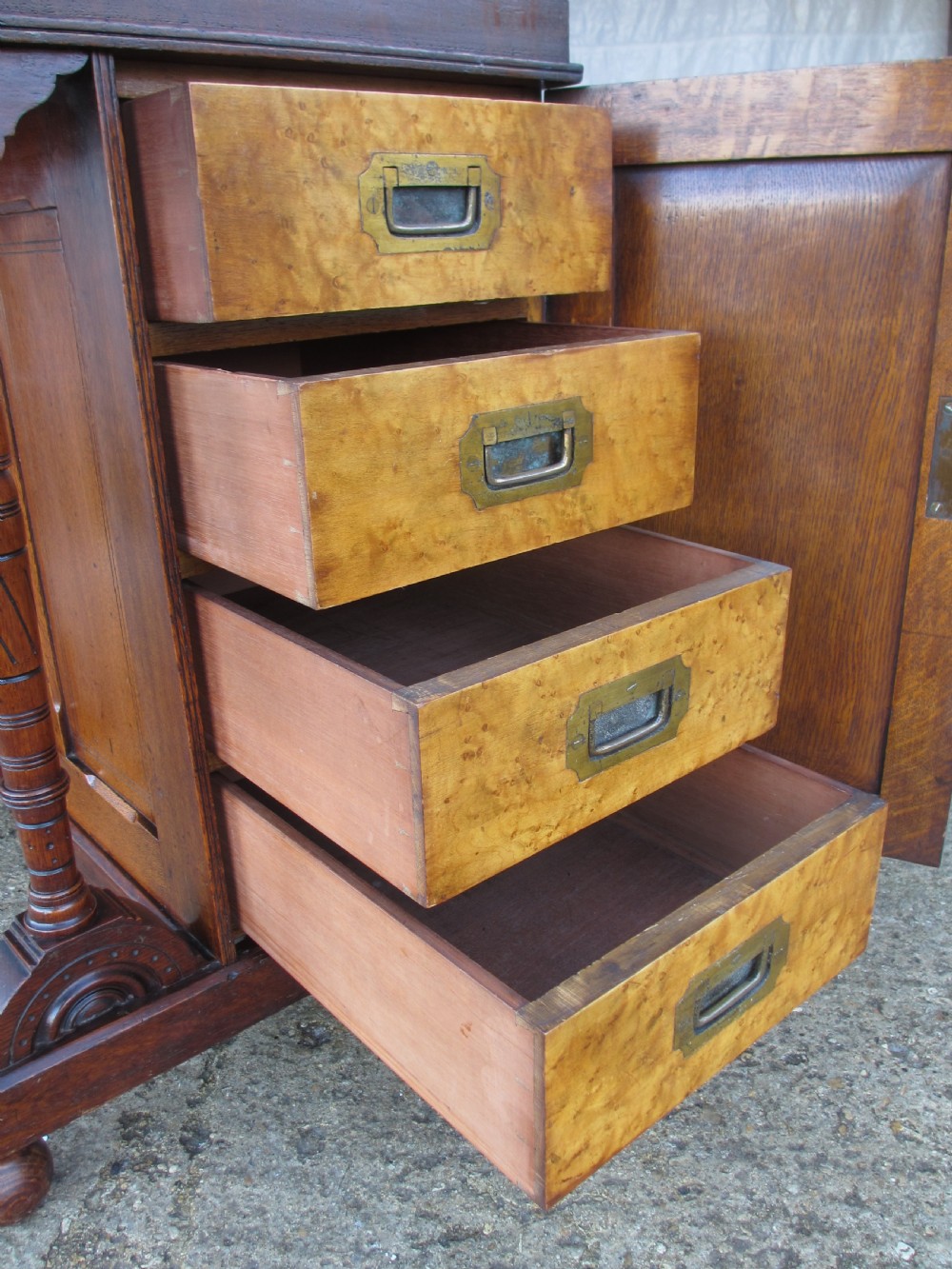 A Victorian oak davenport desk featuring a green leather writing surface, brass gallery rail, and turned front columns. View XVII