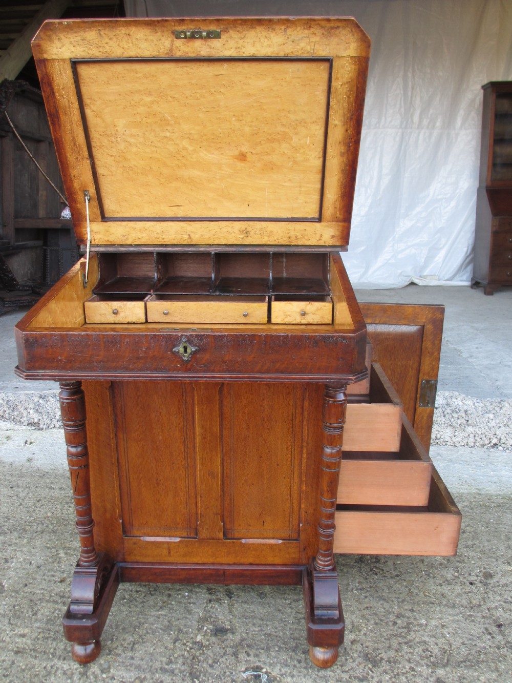 A Victorian oak davenport desk featuring a green leather writing surface, brass gallery rail, and turned front columns. View XVIII