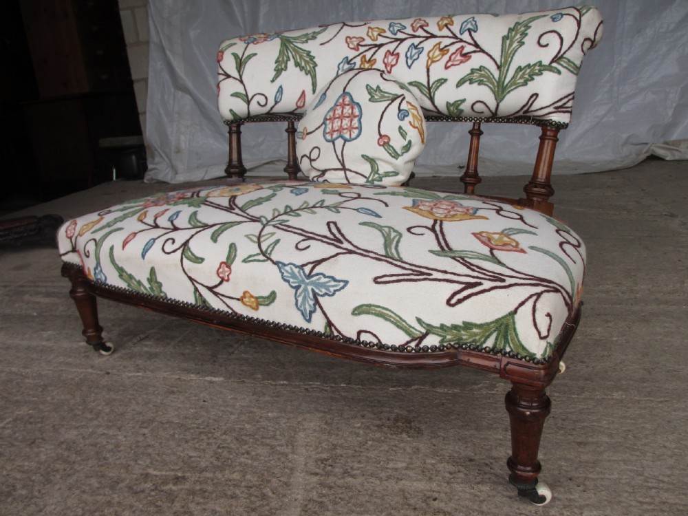 Victorian walnut upholstered window settee with turned and carved crest rail supports, turned forelegs, on castors  View II