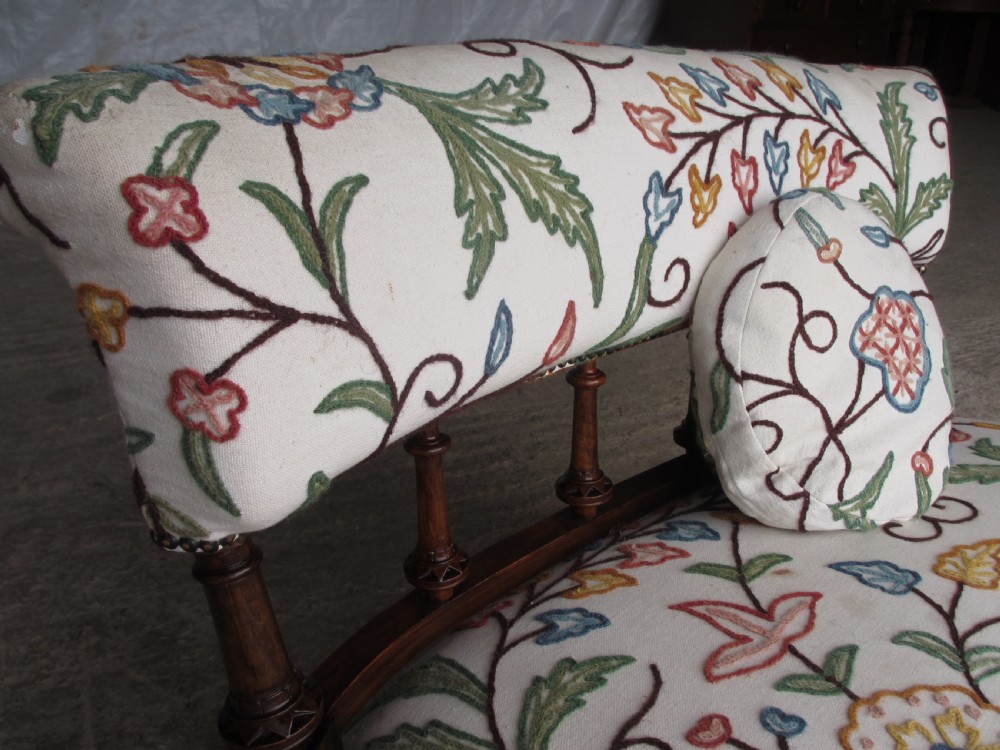 Victorian walnut upholstered window settee with turned and carved crest rail supports, turned forelegs, on castors  View III
