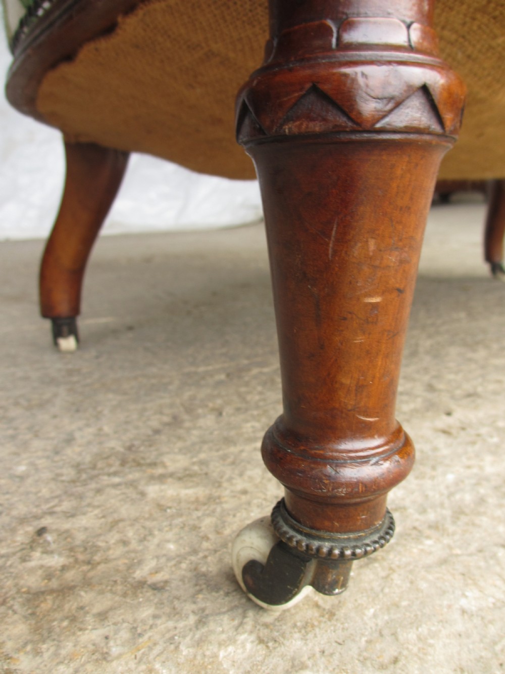 Victorian walnut upholstered window settee with turned and carved crest rail supports, turned forelegs, on castors  View XII