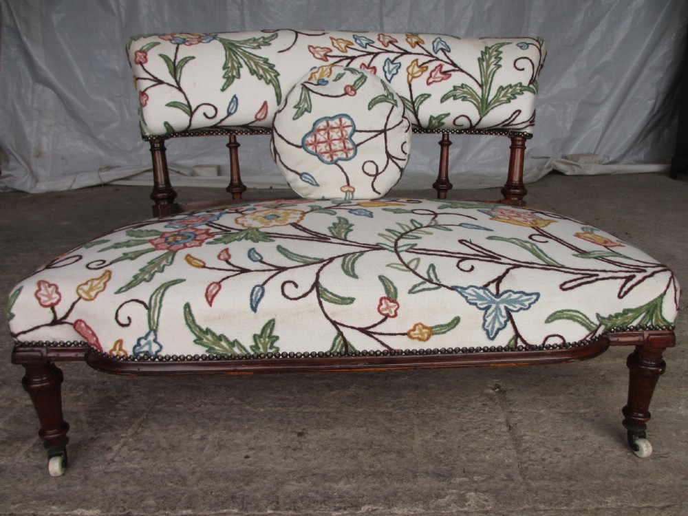 Victorian walnut upholstered window settee with turned and carved crest rail supports, turned forelegs, on castors  View XIII