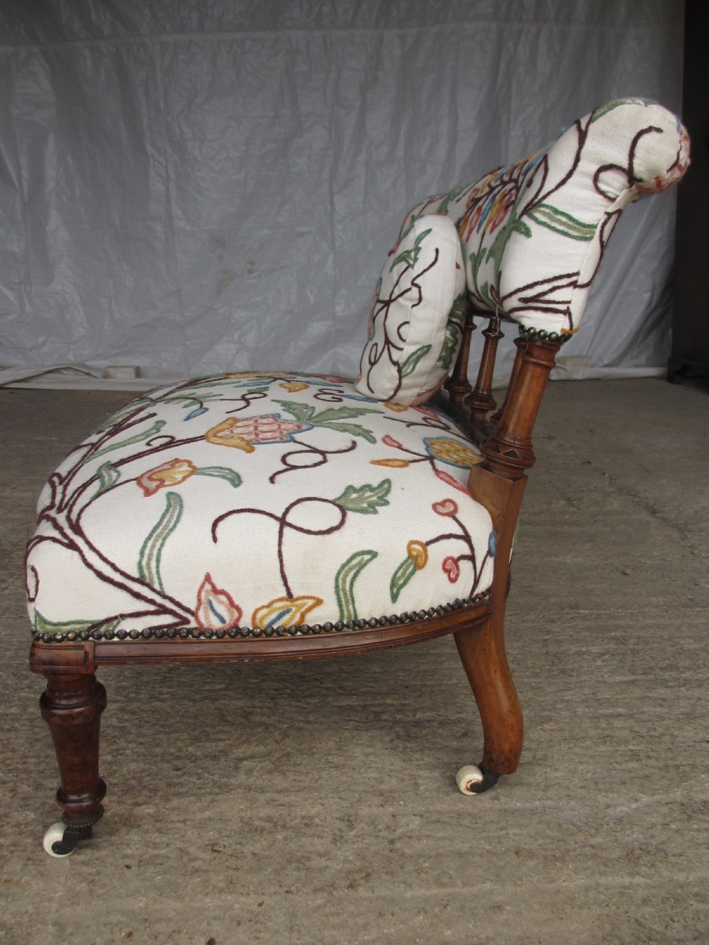 Victorian walnut upholstered window settee with turned and carved crest rail supports, turned forelegs, on castors  View XIV