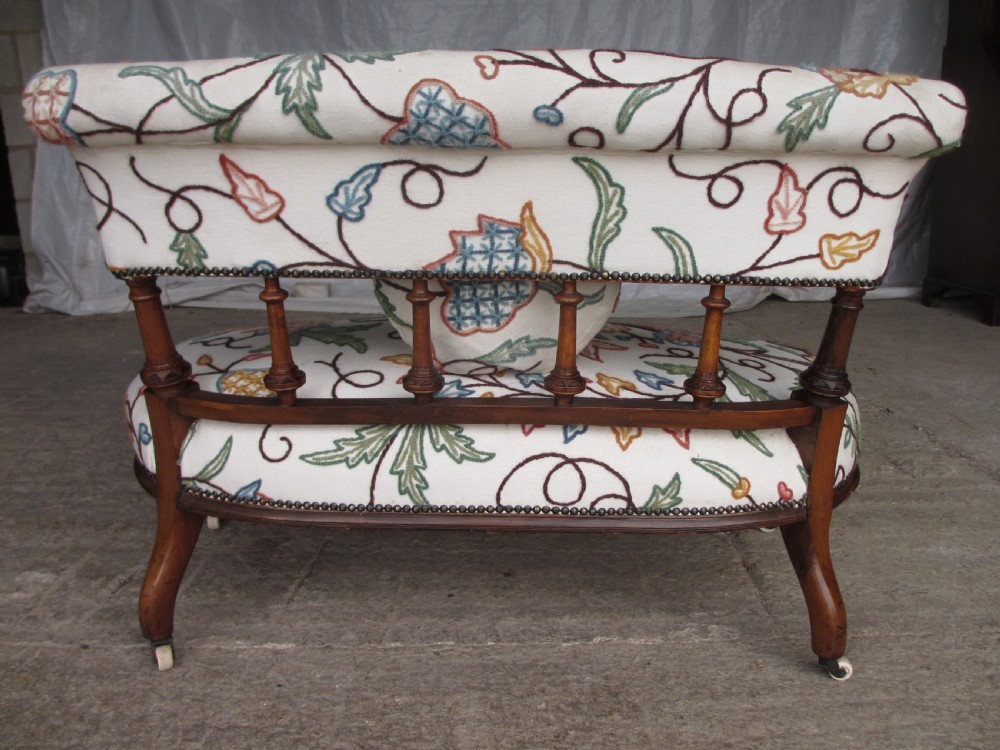 Victorian walnut upholstered window settee with turned and carved crest rail supports, turned forelegs, on castors  View XV