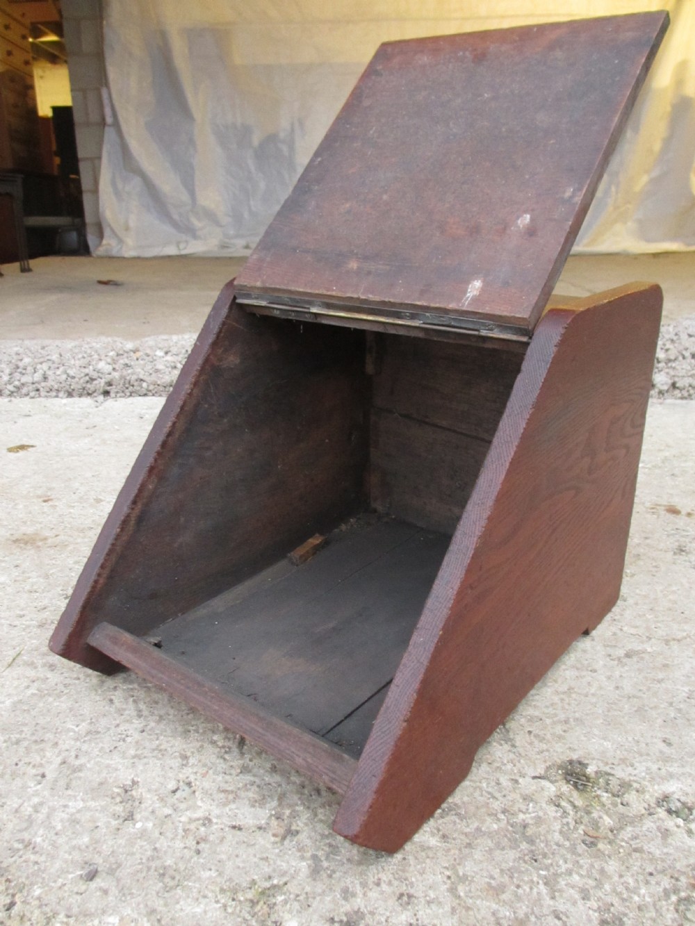 A Victorian dark oak purdonium coal box with a slanted front featuring a relief-carved acanthus leaf panel and a top brass handle. View III