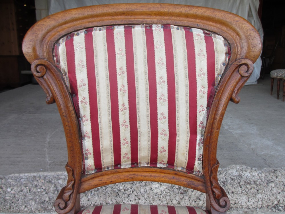 A pair of 19th-century oak balloon back dining chairs featuring red and cream striped upholstery, carved scroll details, and cabriole legs. View V