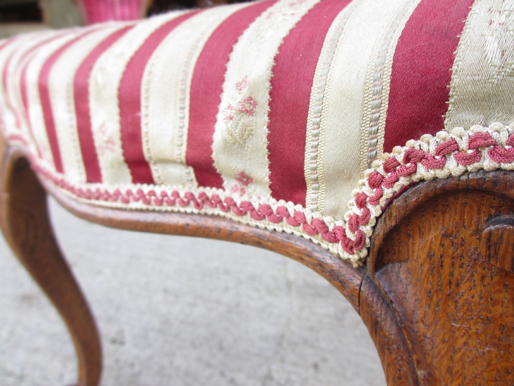 A pair of 19th-century oak balloon back dining chairs featuring red and cream striped upholstery, carved scroll details, and cabriole legs. View XI