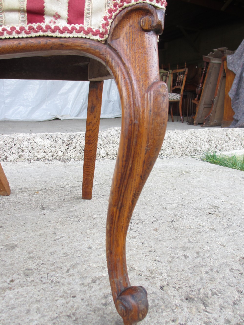 A pair of 19th-century oak balloon back dining chairs featuring red and cream striped upholstery, carved scroll details, and cabriole legs. View XII