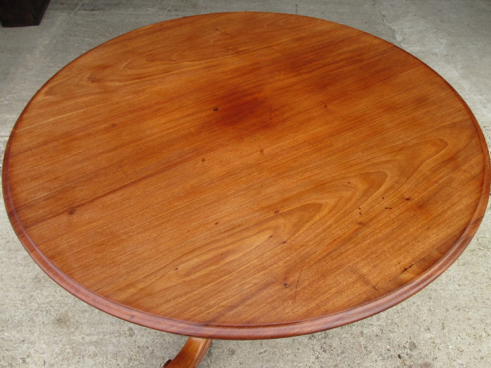 Victorian mahogany circular tilt top table with tripod scrolled legs on castors  View II