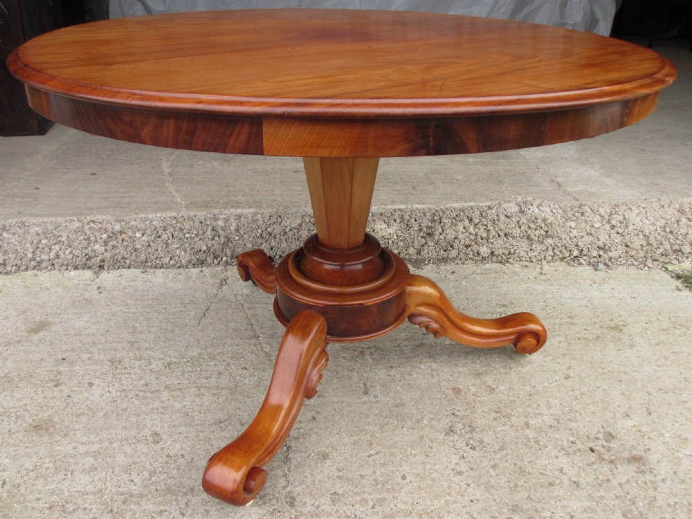 Victorian mahogany circular tilt top table with tripod scrolled legs on castors 
