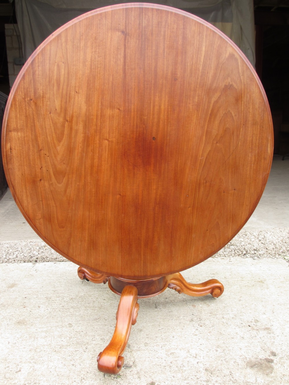 Victorian mahogany circular tilt top table with tripod scrolled legs on castors  View X