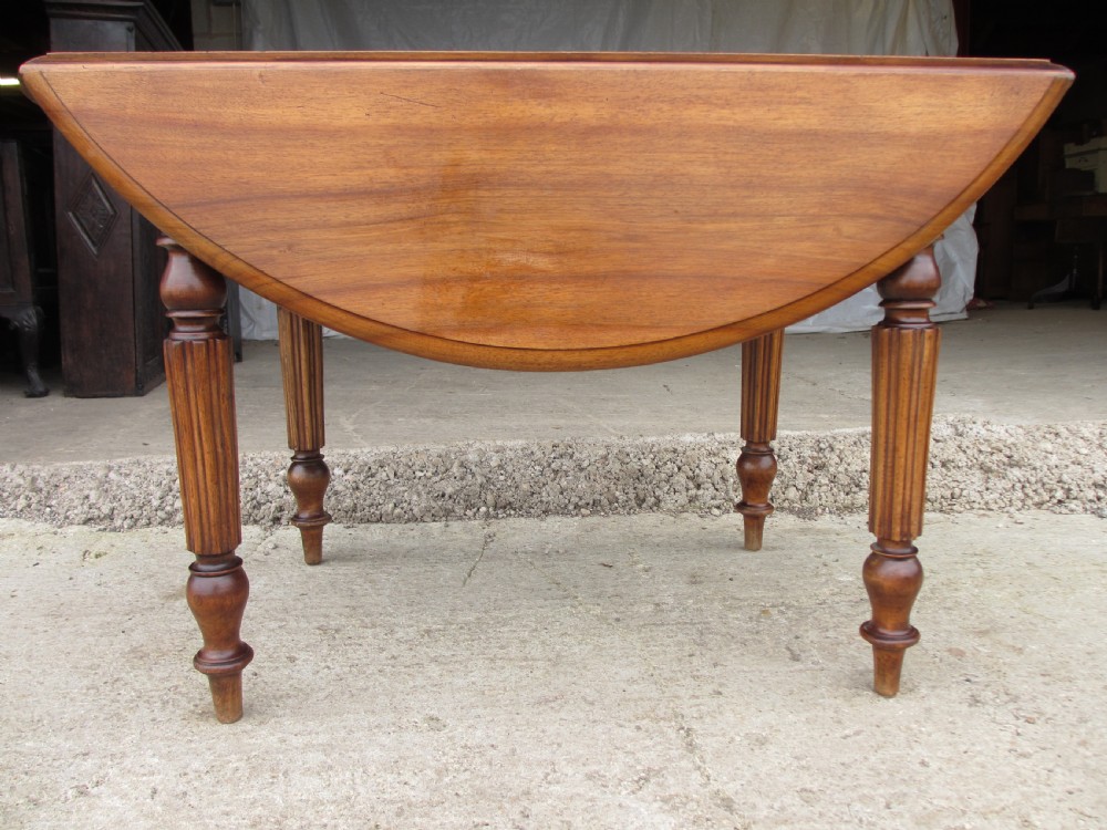 Victorian mahogany circular top drop leaf dining table turned reeded supports View II