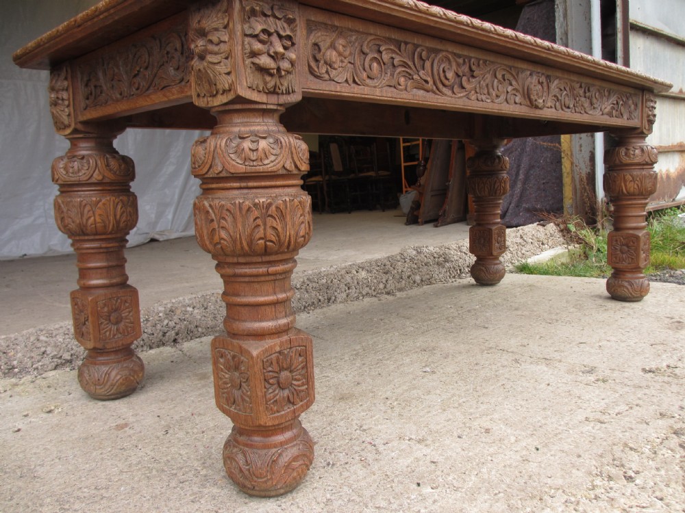 Victorian carved heavy oak dining table with lion heads and floral and leaf frieze on solid oak supports View IV