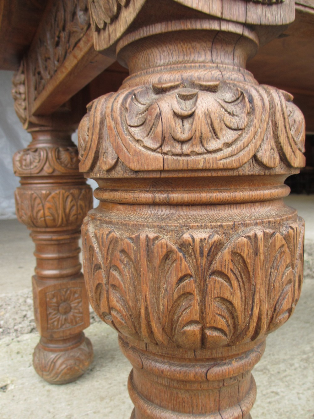 Victorian carved heavy oak dining table with lion heads and floral and leaf frieze on solid oak supports View V