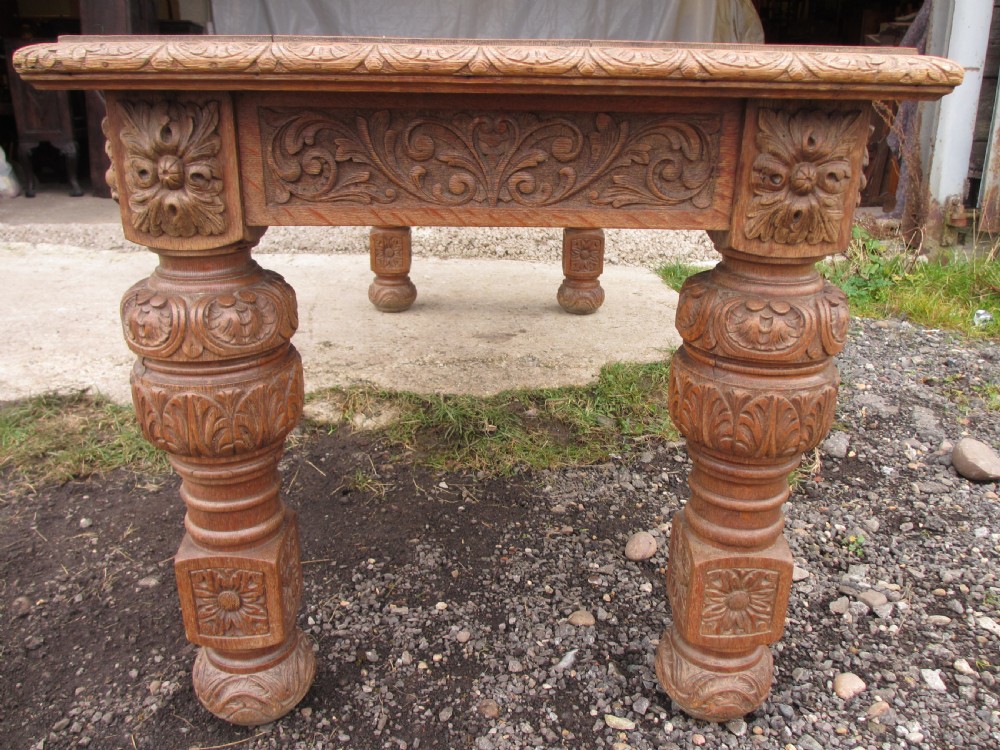 Victorian carved heavy oak dining table with lion heads and floral and leaf frieze on solid oak supports View VIII