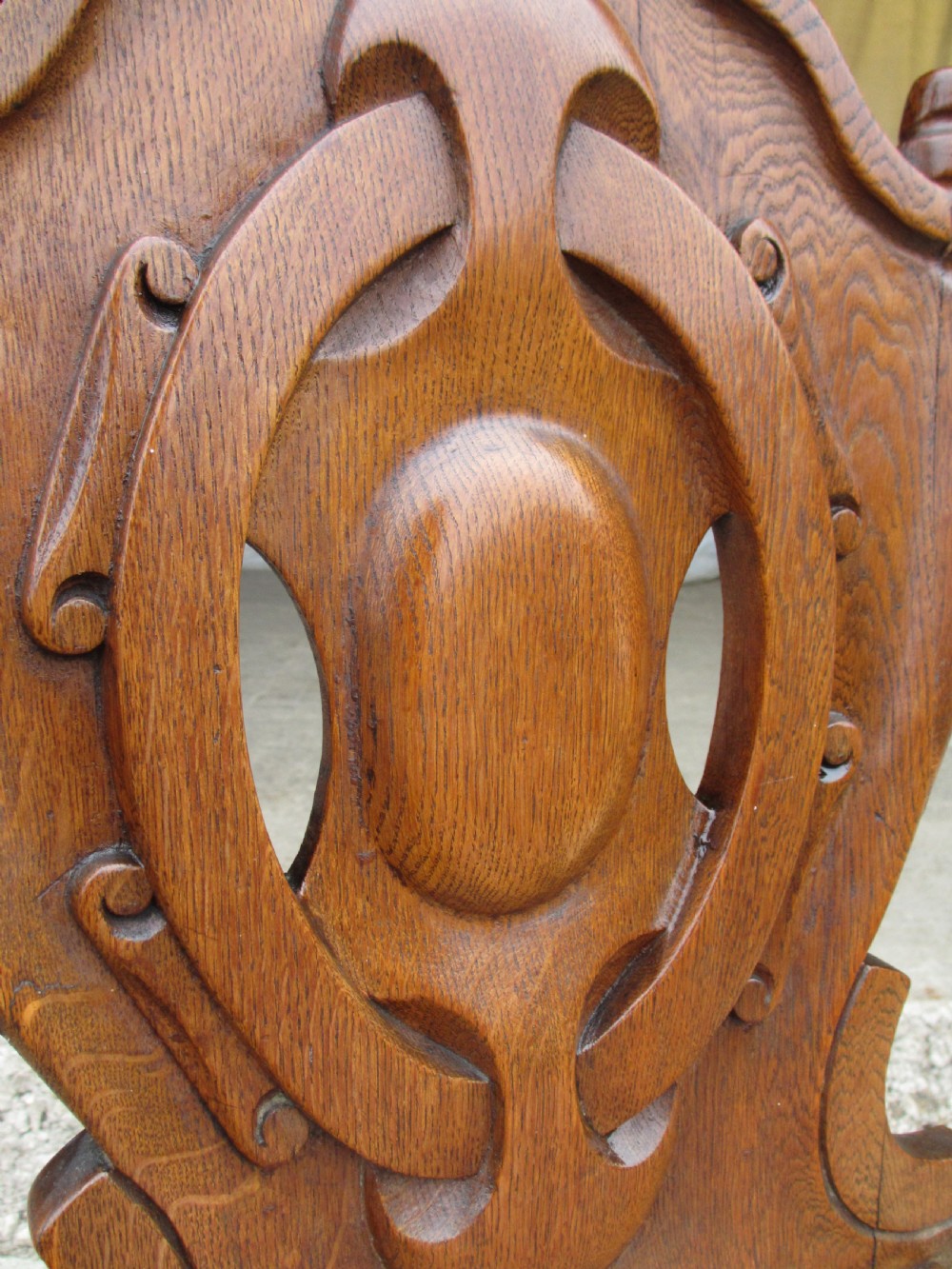 A pair of Victorian carved golden oak hall chairs featuring openwork shield backs with central cartouches, solid wooden seats, and cabriole front legs. View IV