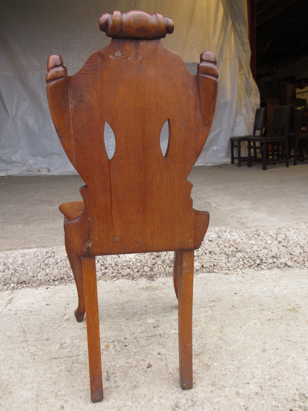 A pair of Victorian carved golden oak hall chairs featuring openwork shield backs with central cartouches, solid wooden seats, and cabriole front legs. View XIII