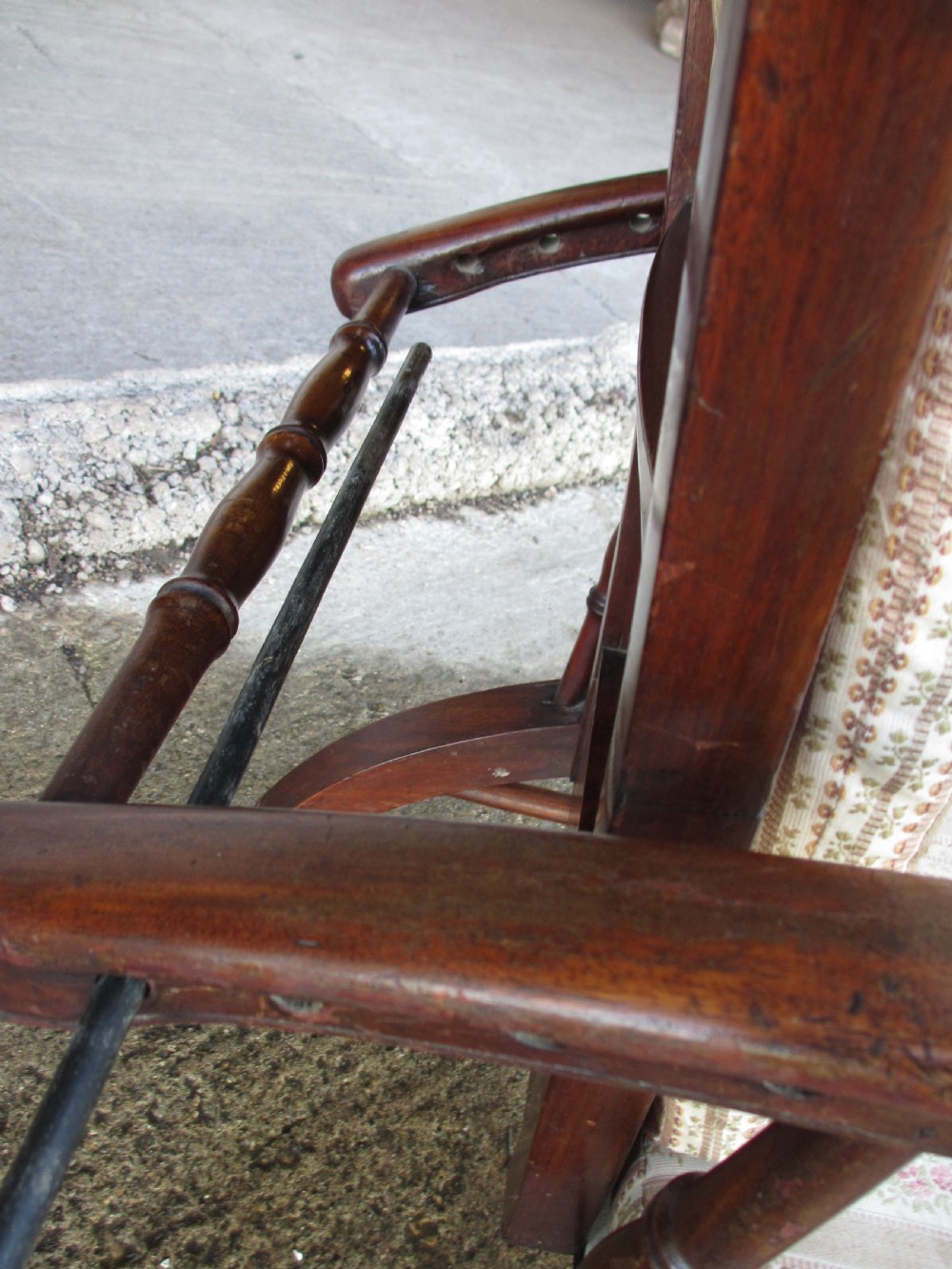 A 19th-century dark mahogany armchair featuring turned side spindles, beige striped upholstery, an adjustable reclining backrest, and brass castors. View VIII