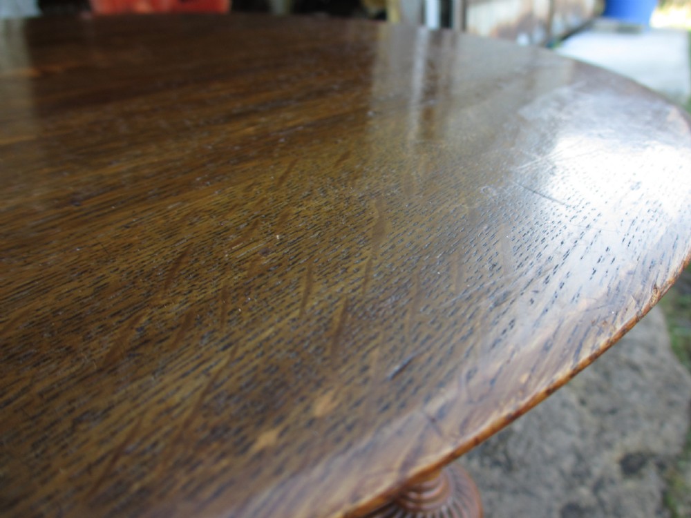 An Edwardian oak circular occasional table featuring three carved spiral-bulb legs, a shaped apron, and a lower triangular tier shelf. View III