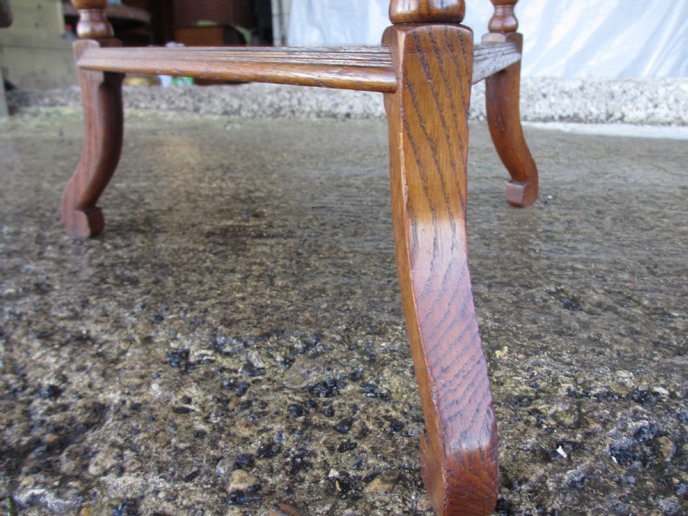 An Edwardian oak circular occasional table featuring three carved spiral-bulb legs, a shaped apron, and a lower triangular tier shelf. View IX