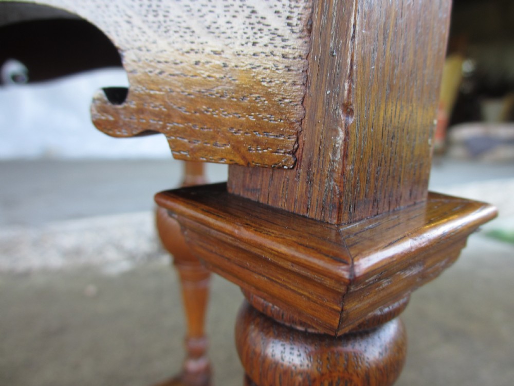 An Edwardian oak circular occasional table featuring three carved spiral-bulb legs, a shaped apron, and a lower triangular tier shelf. View XIII